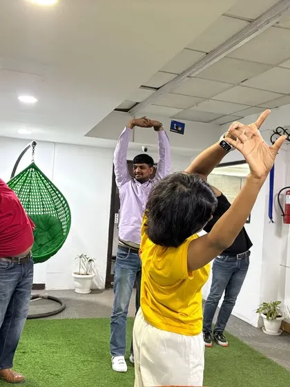 Energizing the body after hours of sitting is crucial. Here, employees engage in a standing side stretch, a simple yet effective asana to open up the sides of the body, improve circulation, and boost energy levels during the workday.