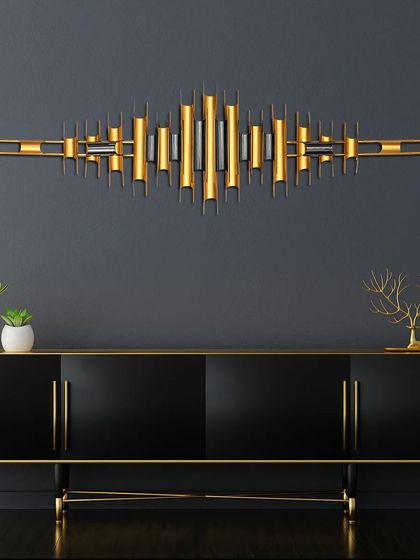 This abstract metal wall art is inspired by the look of a soundwave. The gold and black metal tubes are arranged in a dynamic, horizontal pattern, making it a perfect piece to hang above a console or sideboard.