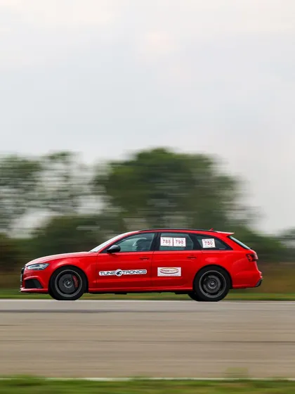 The blur of a red Audi RS6 Avant at speed. Our photographers capture the dynamic motion that defines the drag racing experience, creating compelling visuals for all to see.