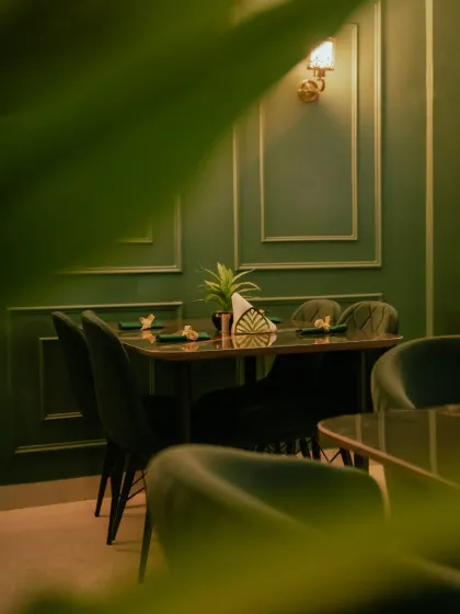 Another perspective of the dining area, showing the warm lighting and sophisticated wall molding.