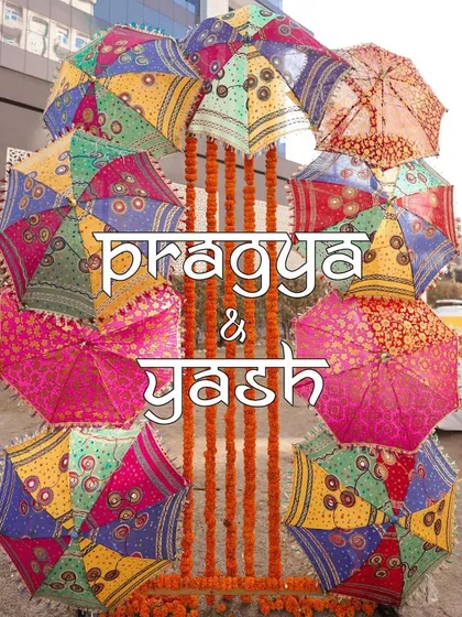 A fun and colorful photo booth backdrop made of Rajasthani-style umbrellas, personalized with the couple's names.