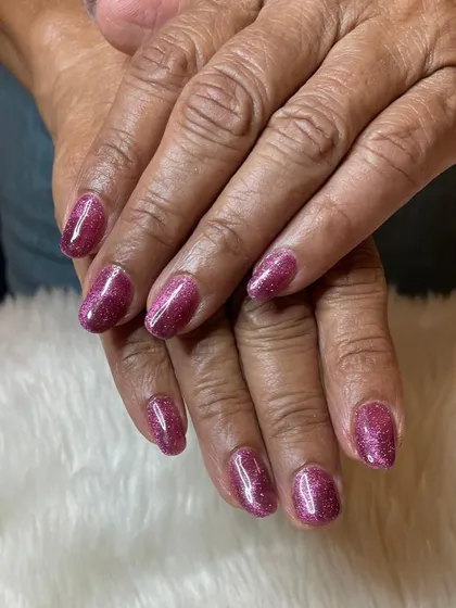 A recap photo showing a sparkling pink glitter polish on natural nails.