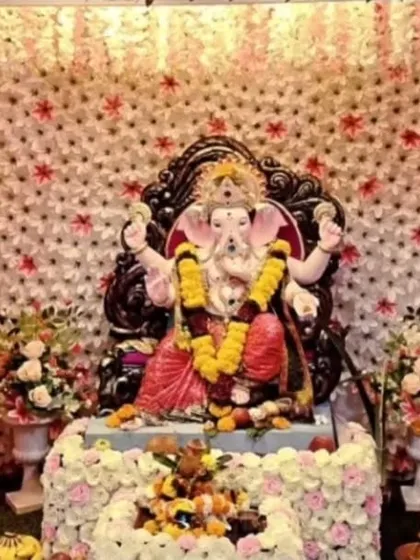 This decor features columns of pink and white flowers framing a backdrop of star-shaped white florals. It's a textured and visually interesting design for a modern Ganpati celebration.