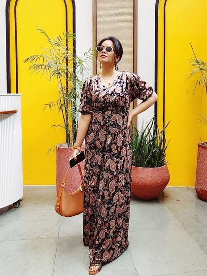 Another angle of the paisley maxi dress, this time against a bright yellow background, showing how the outfit stands out.