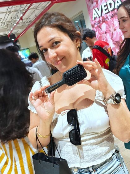 A guest at the GHD event proudly showing off her new personalized hairbrush. These moments of connection make every event special.