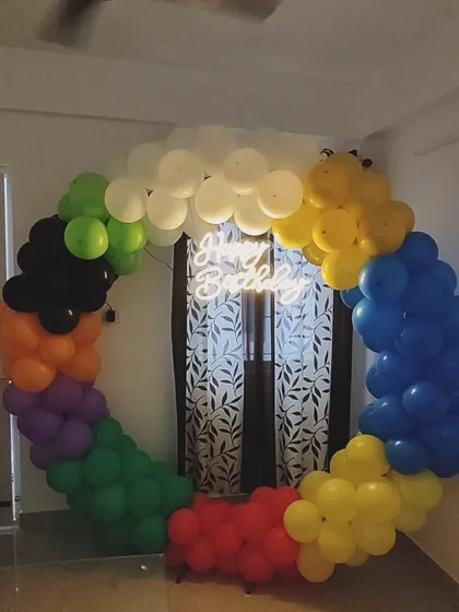 To create a fun and vibrant party atmosphere, I built this rainbow-colored balloon hoop. The addition of a bright neon 'Happy Birthday' sign in the center makes it a modern and eye-catching decoration.
