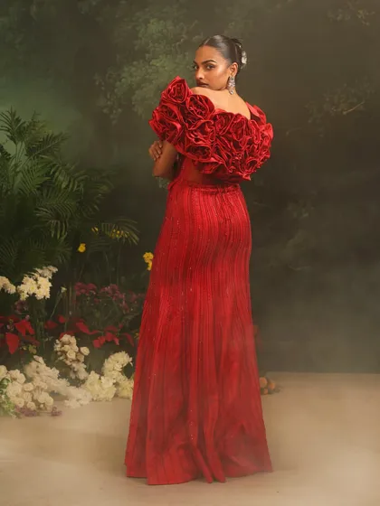 The back of the red Bellerose Gown, showcasing the dramatic 3D rose cape that flows with regal elegance. A true statement of couture craftsmanship.