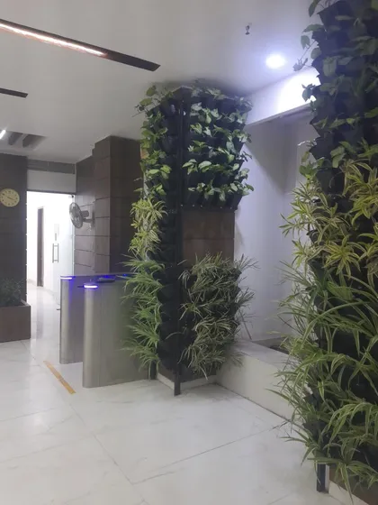 A completed vertical garden pillar at Era Infra Eng. Ltd, strategically placed near the entrance turnstiles to create an immediate green impact for employees and visitors.