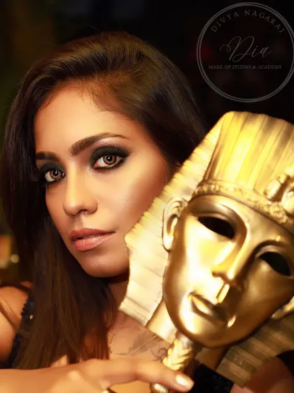 A soft glam look with an artistic twist. The smoky eye and glowing skin are paired with an Egyptian-themed prop, showing how makeup can be used to tell a story.