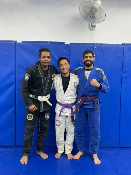 Three practitioners representing different belt levels. This image highlights the journey of progress in Brazilian Jiu-Jitsu, from purple belt to black belt.