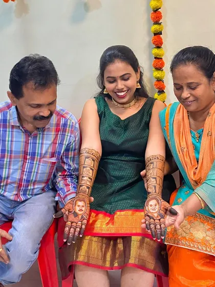 The bride's parents admiring the henna portraits of themselves on their daughter's hands. These moments are what make personalized mehendi so special.