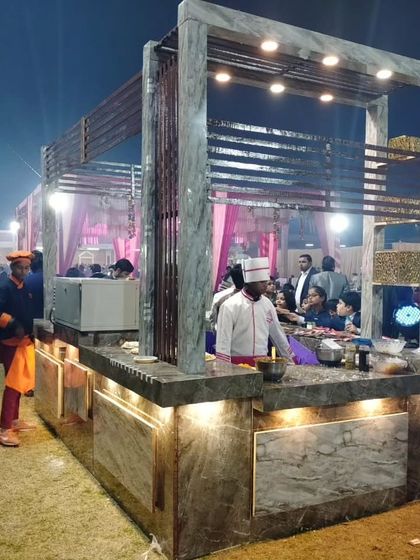A side view of the live station, showcasing the structure and the chef interacting with the food. The setup is both functional and aesthetically pleasing.