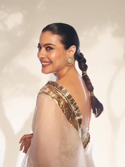 This over the shoulder shot reveals the stylishly braided ponytail and the sparkle of the gold blouse, completing this premiere night look.