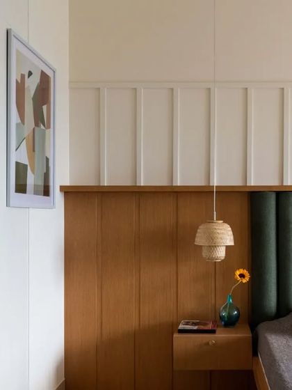A detail of the master bedroom's custom headboard and wall paneling. The design adds texture and architectural interest to the space.