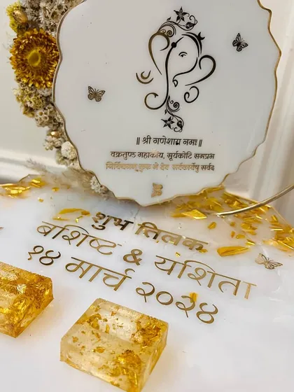 A close-up of the Hindi text and the gold-flake ring holders on the Ganesha-themed platter.