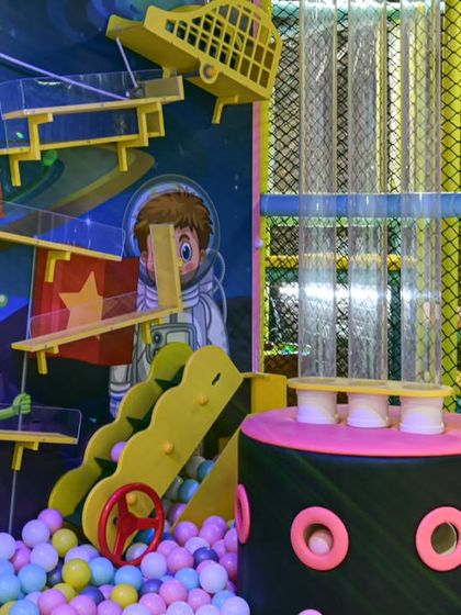 A close-up of our space-themed ball machine and ball pit. This area is a hub of activity, where kids can play with the transparent tubes and swim in a sea of balls.