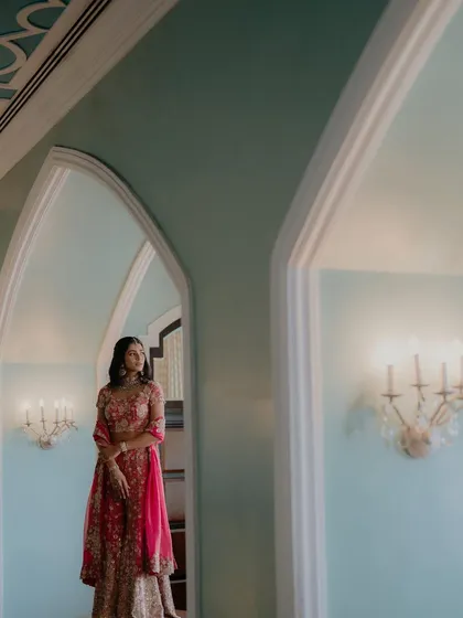A wide shot that uses the beautiful architecture and interior design of the palace to frame the bride. This portrait emphasizes elegance and a sense of place.