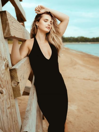 A powerful and sensual pose on the beach, with the model's eyes closed, soaking in the sun and the sea breeze.