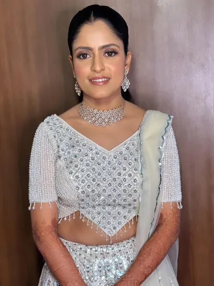A smiling portrait of Surabhi. The neutral makeup palette is versatile and complements any modern bridal outfit.