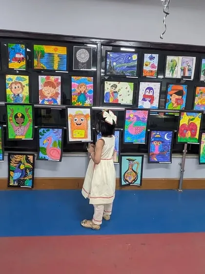 A young artist completely captivated by the gallery wall at our exhibition. This moment perfectly captures the wonder and inspiration that art brings, showing how we encourage even our youngest students to appreciate and engage with creativity.