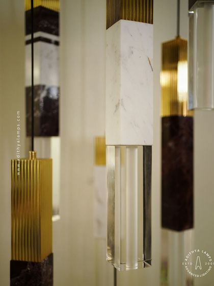A collection of our pillar pendants, which combine sections of solid marble, fluted metal, and clear crystal. These substantial, high-quality fixtures can be hung individually or in clusters to create a dramatic effect in stairwells or entryways.