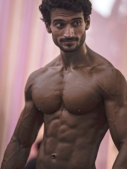 A candid shot from a competition, showing the physique in a relaxed but defined state.