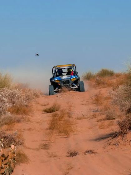 A wider BTS shot showing my drone tracking a Polaris ATV from behind during an off-road race.