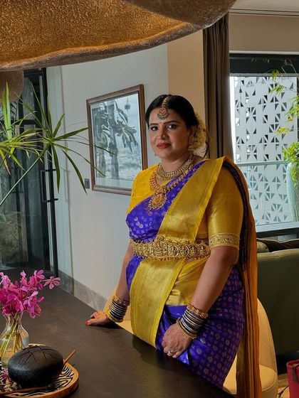 Our client Priya looks stunning in a classic Kanchivaram designer silk saree in royal blue and gold.