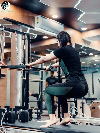 This high half-toes squat on the Cadillac tower is an advanced move that builds strength in the quads, glutes, and calves while demanding significant core engagement for balance.