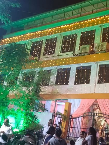 The exterior of Ashoka Banquet hall in Vashi, lit up for an evening event. The building has a grand presence, promising a special celebration inside.