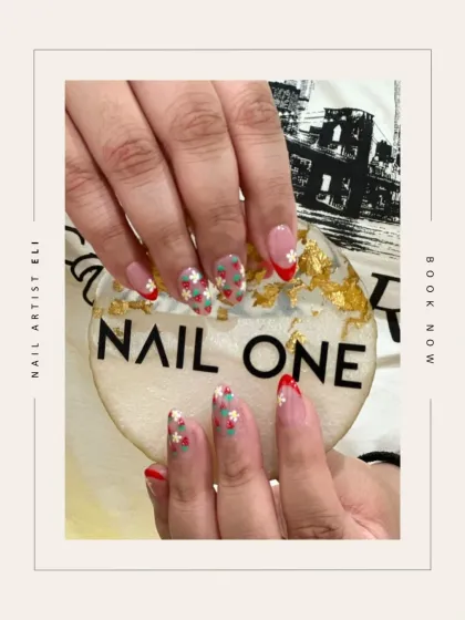 A creative twist on a French manicure, featuring tiny, hand-painted strawberries and a bold red tip. This design, created by our artist Eli, shows how we can personalize a classic look with charming details.