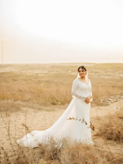 A wide shot of the bride on the beach, her dress looking magnificent against the natural landscape.