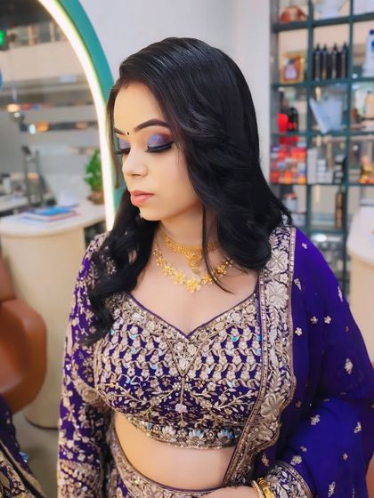 A close-up on the eye makeup for this party look. The shimmery purple and blue eyeshadow makes her eyes pop and perfectly matches her detailed lehenga.