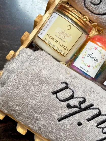 A detailed look at the personalized wedding hamper. You can see the beautiful embroidery on the towel next to my handmade French Vanilla candle and colorful bath salts.