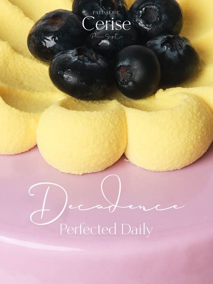 Decadence Perfected Daily. A close-up of a fruit entremet, showing the detailed piping and fresh blueberry garnish.