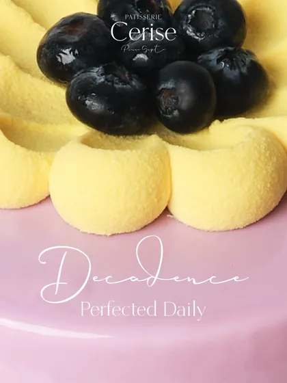 Decadence Perfected Daily. A close-up of a fruit entremet, showing the detailed piping and fresh blueberry garnish.