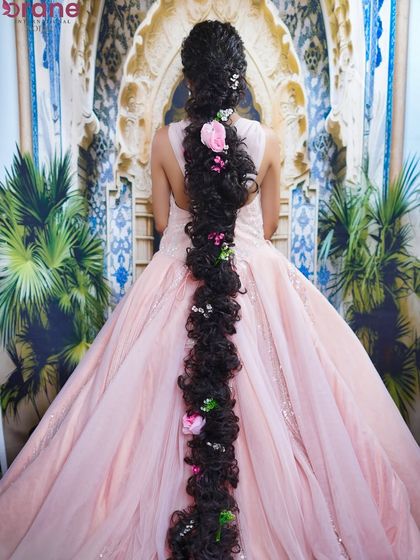 The back view showcases the magnificent, floor-length braid, a true masterpiece of hairstyling.