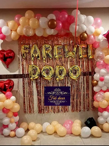Beyond birthdays, I provide decorations for other special events like farewell parties. This setup includes a balloon arch and a shimmer curtain backdrop with "FAREWELL DODO" in large gold foil letters to celebrate a colleague.