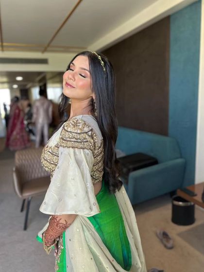 A serene, sun-kissed portrait. The makeup is flawless and glowing, enhancing her natural beauty.