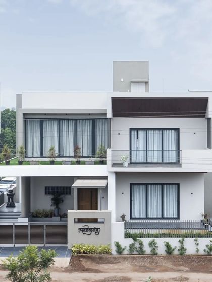 The home's modern exterior, captured with a passing horse-drawn cart, creates a poignant image of contemporary design in a traditional Indian context.