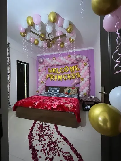 I can transform your bedroom into a beautiful sanctuary to welcome your little princess. This decoration includes a 'Welcome Princess' balloon arch over the bed, balloons on the ceiling, and a traditional rose petal pathway for that extra special touch.