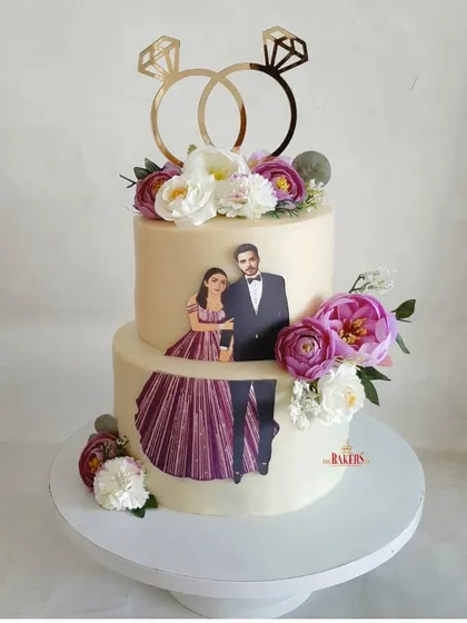 I loved creating this unique lavender and white two-tier engagement cake for Ankita and Daksh. It features a custom edible print of the couple, framed by beautiful purple and white peonies and topped with a custom ring topper.