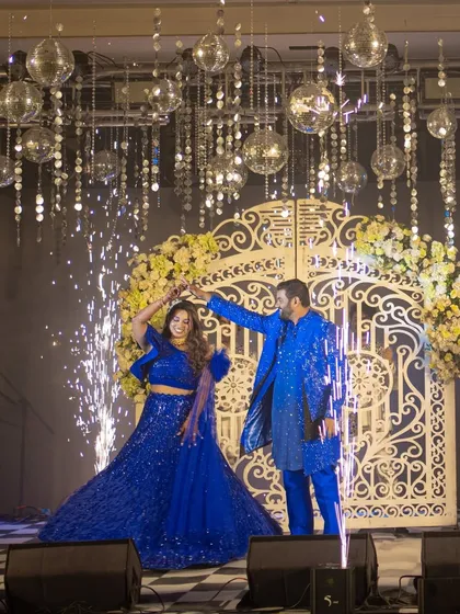 A perfect sangeet moment captured. The couple makes their grand entrance under a shower of disco balls, framed by a beautiful floral gate and lit up by cold pyro, creating a high-energy, picture-perfect memory.