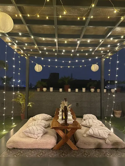 Here is a look at one of my signature boho-chic picnic setups. With low seating on plush cushions, pampas grass accents, and a canopy of fairy lights and paper lanterns, it’s the perfect vibe for a relaxed and soulful evening.