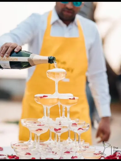 Our bartender expertly pouring a champagne tower. The addition of rose petals in the glasses adds a touch of romance to this classic celebratory moment.