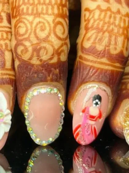 A close-up of the bespoke bridal nail art, highlighting the hand-painted bride figure, a 3D flower, and a nail fully bordered with sparkling rhinestones.