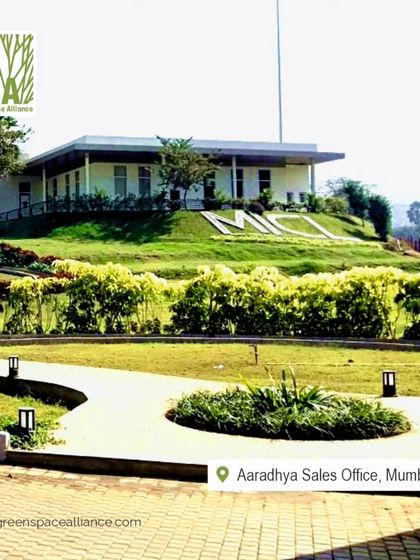 The landscape for the Aaradhya Sales Office in Mumbai features rolling green lawns and manicured hedges. This design creates a lasting positive impression and reinforces the project's commitment to a high-quality, green environment.