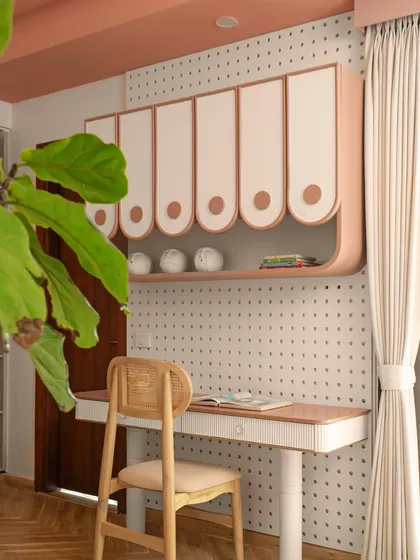 A dedicated study area is essential. This custom desk is paired with playful, curved overhead storage and a versatile pegboard wall, providing a perfect spot for creativity and focus that can be personalized over time.