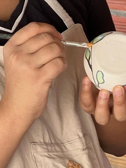 A close-up of a student painting details on their piece. It's amazing to see the care and attention they put into their work.