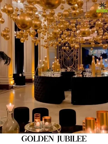 We transform venues to bring any theme to life. For this Golden Jubilee celebration, we created a luxurious atmosphere with a ceiling of suspended golden orbs and elegant black and gold decor.